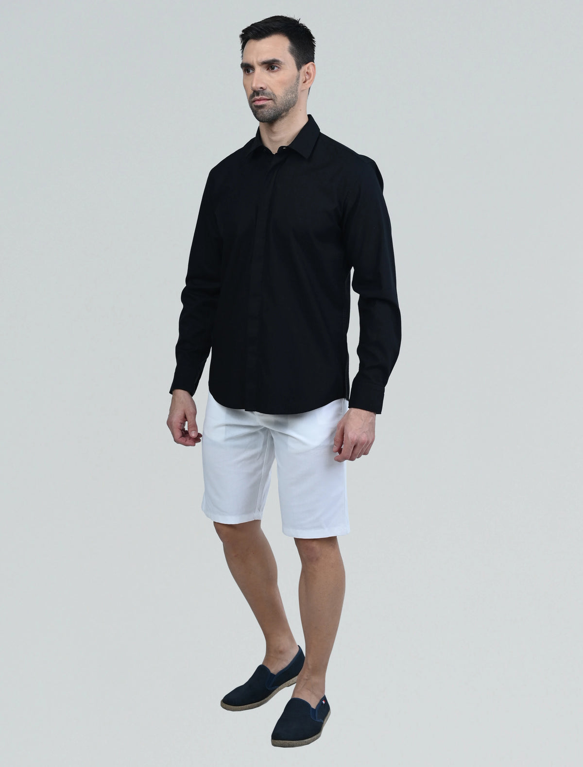 Model wearing the Marshall Menswear Lucien Black men's casual shirt with white shorts, highlighting breathable  fabric and an effortless casual look.