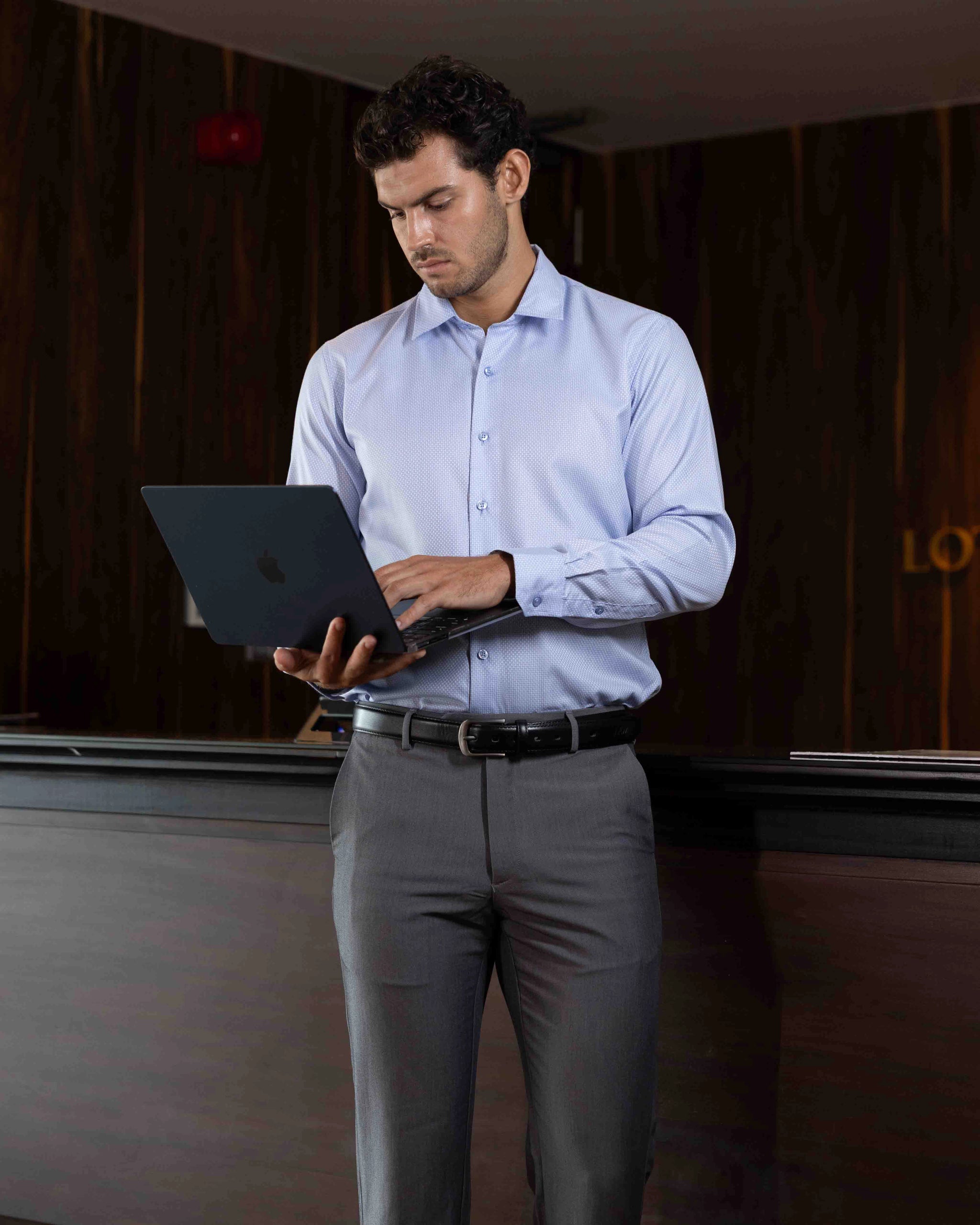 Model wearing the Marshall Menswear Montague Light Blue men's textured dress shirt styled with navy tailored trousers for a refined smart casual look that transitions effortlessly from office to evening.
