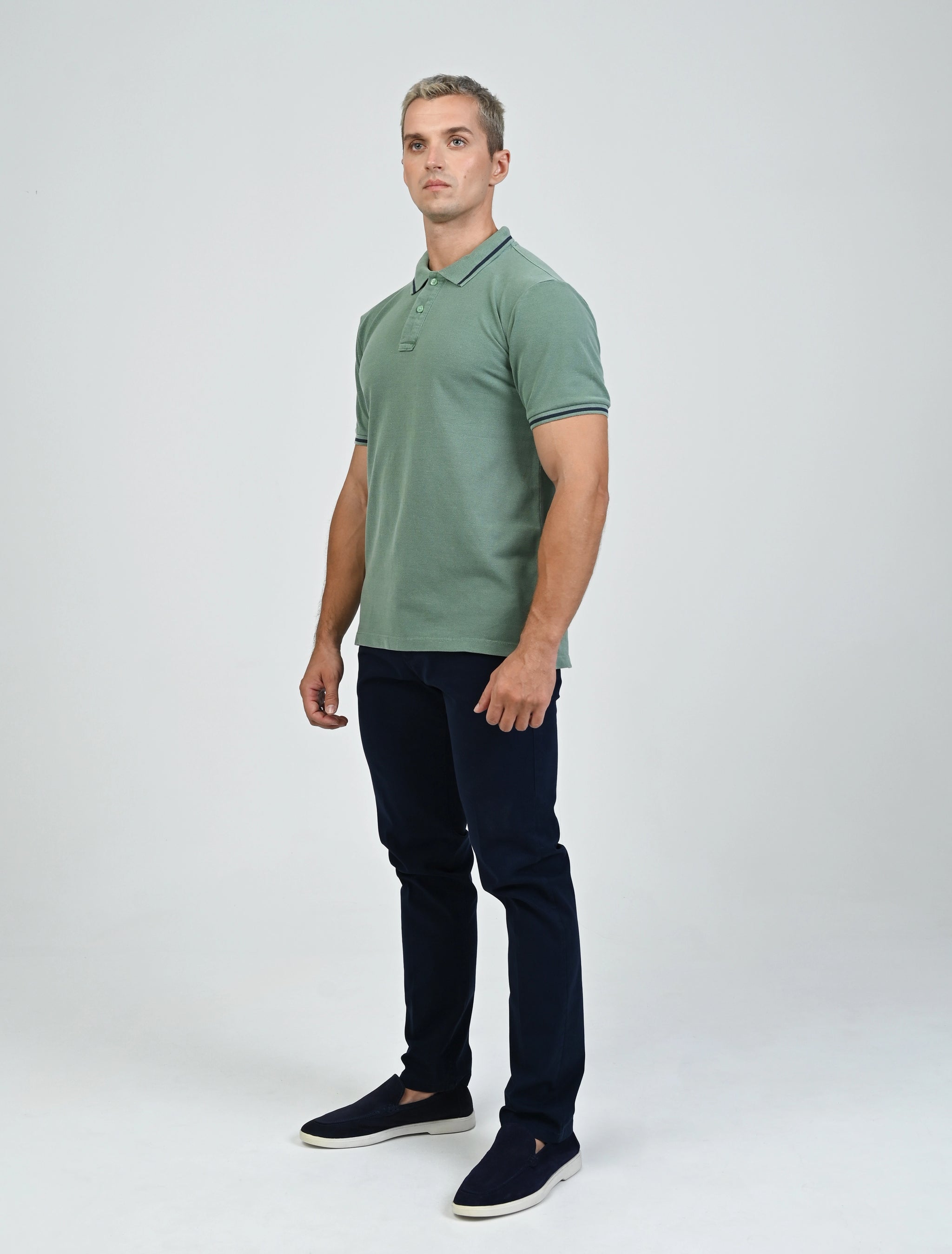 Full-length view of a model wearing the Marshall Menswear Fairmont Emerald Green contrast-tipped polo shirt with navy chinos and loafers for a polished everyday look.
