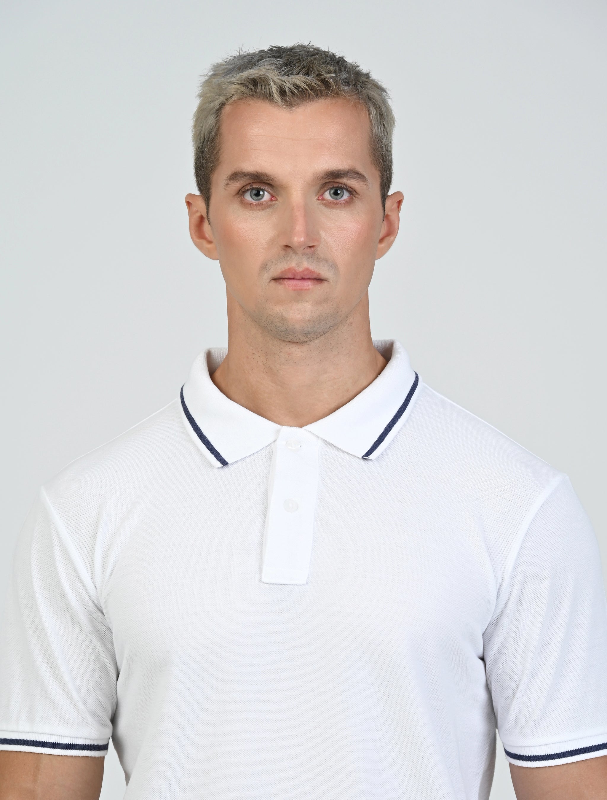 Close-up of the Marshall Menswear Laurent White men's polo shirt highlighting breathable  pique fabric, contrast navy tipping, classic polo collar and two-button placket.