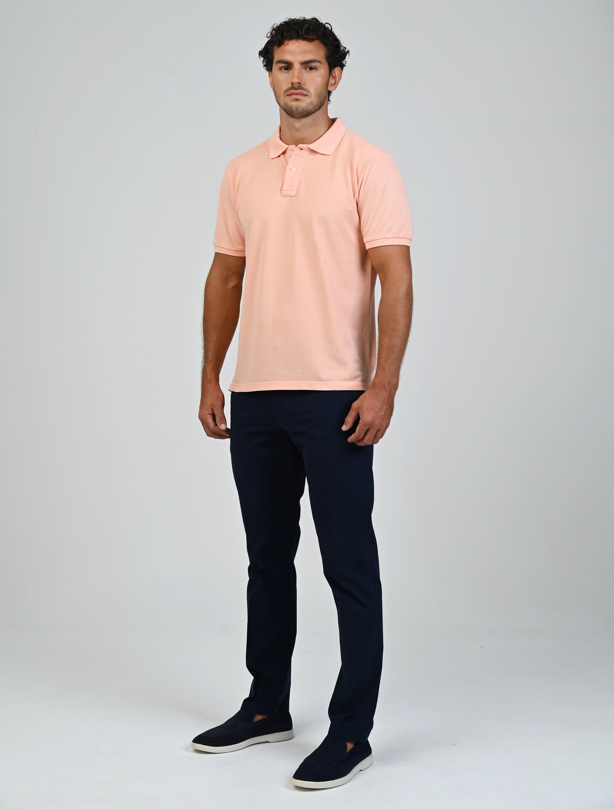 Model wearing the Marshall Menswear Atelier Apricot men's polo shirt with black tailored trousers for a smart business casual office look.