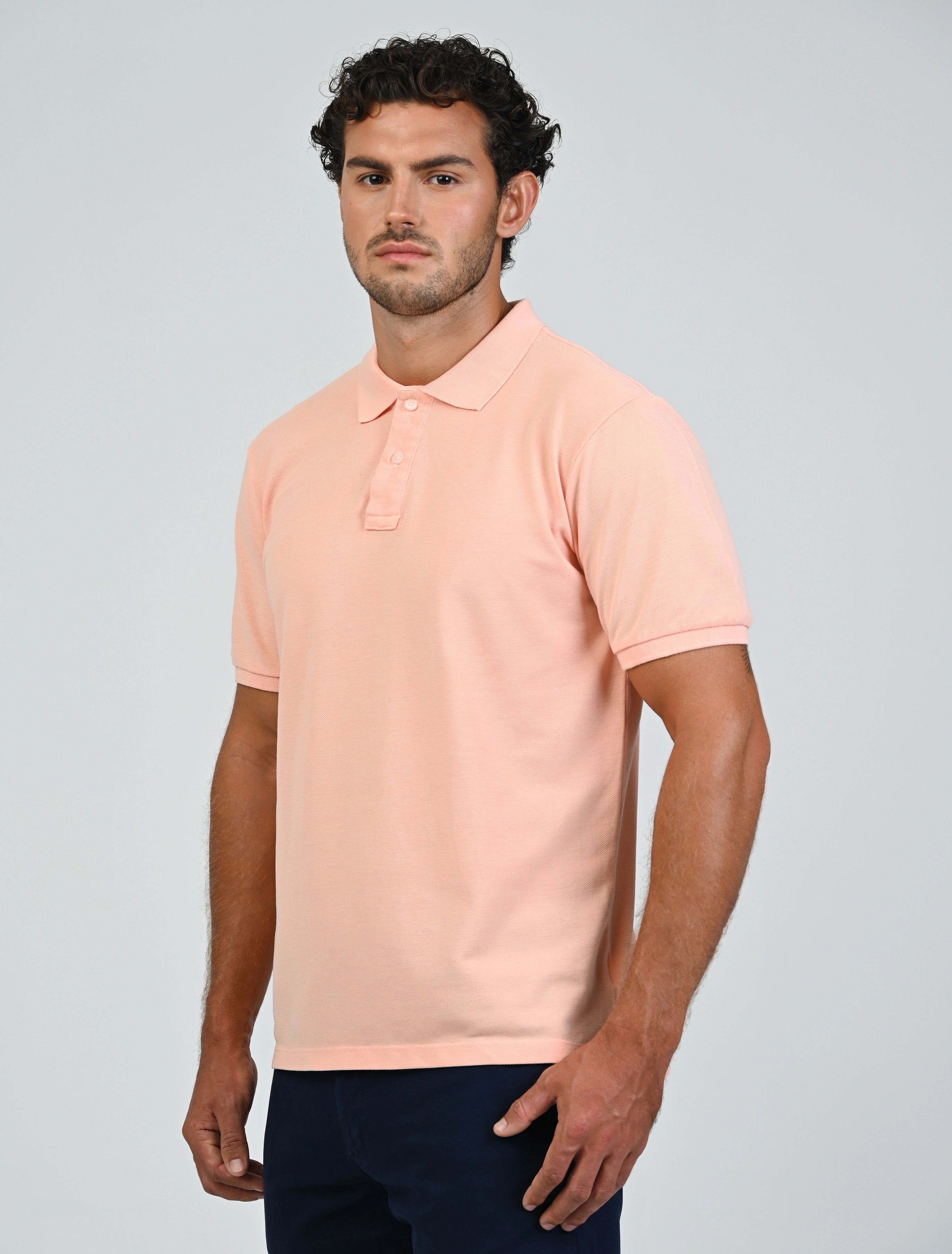 Three-quarter view of Marshall Menswear Atelier Apricot men's polo shirt with tailored fit,  pique fabric and short sleeves for smart casual wear.