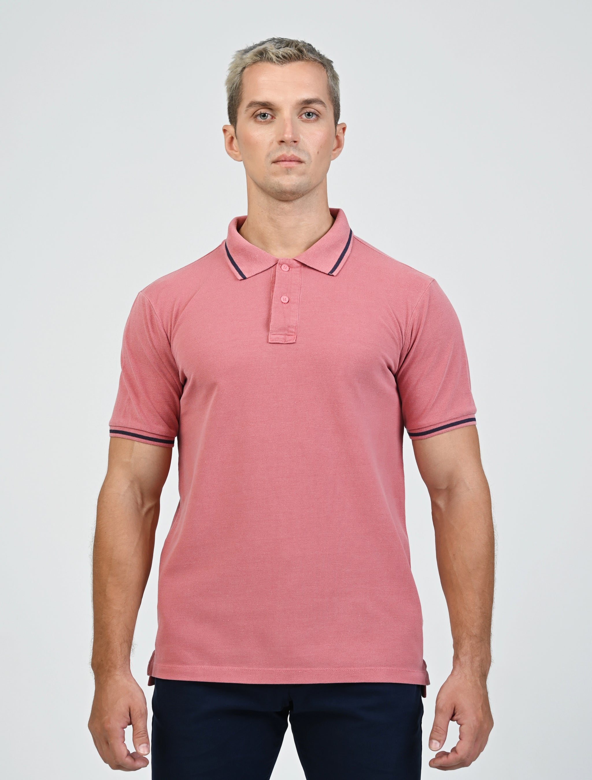 Model wearing the Marshall Menswear Norton Blush Red men's polo shirt with contrast navy tipping, paired with navy chinos for a refined smart casual look.