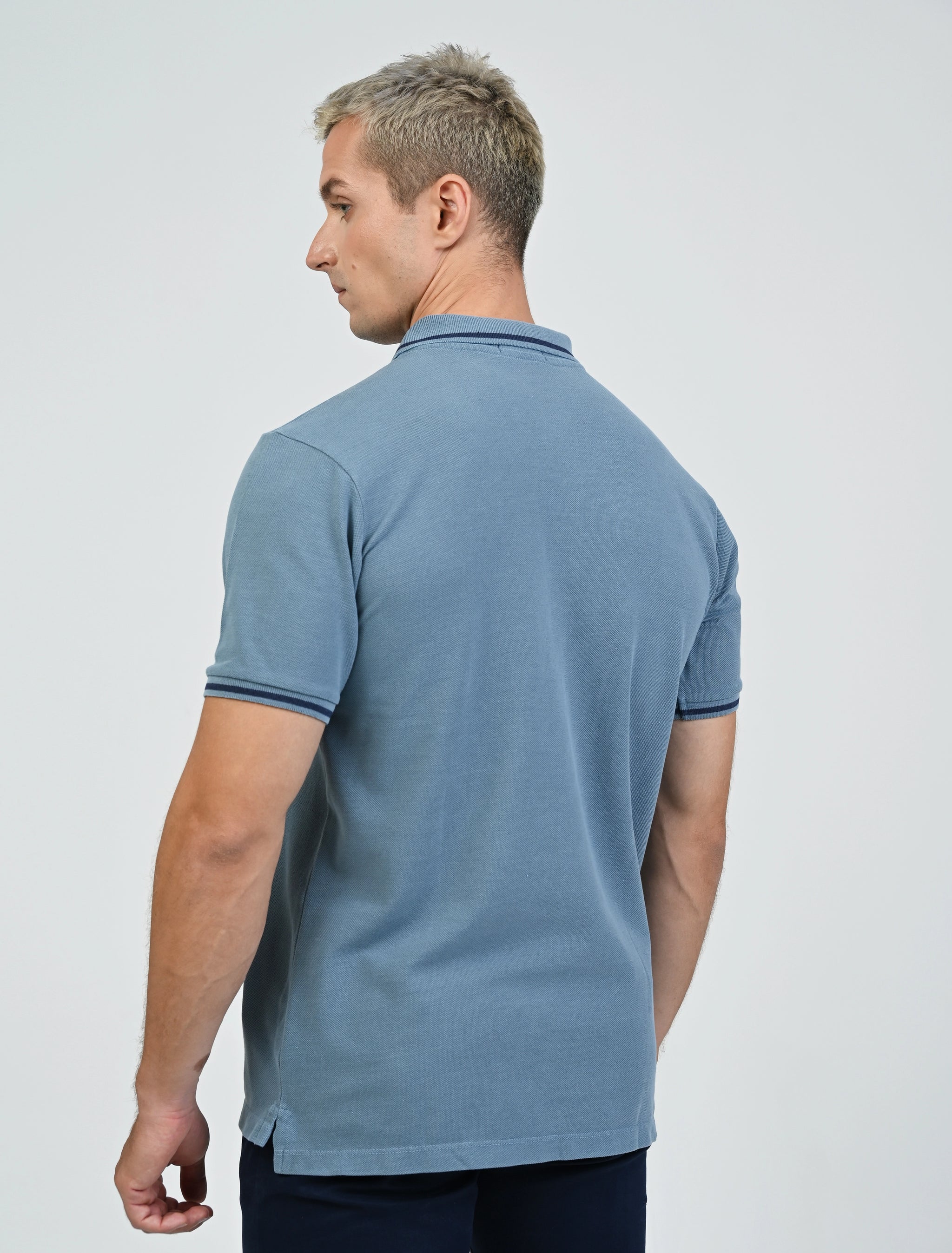 Back view of a model wearing the Marshall Menswear Saville Air Force Blue men's polo shirt with contrast blue tipping, navy chinos for an elevated smart casual outfit.