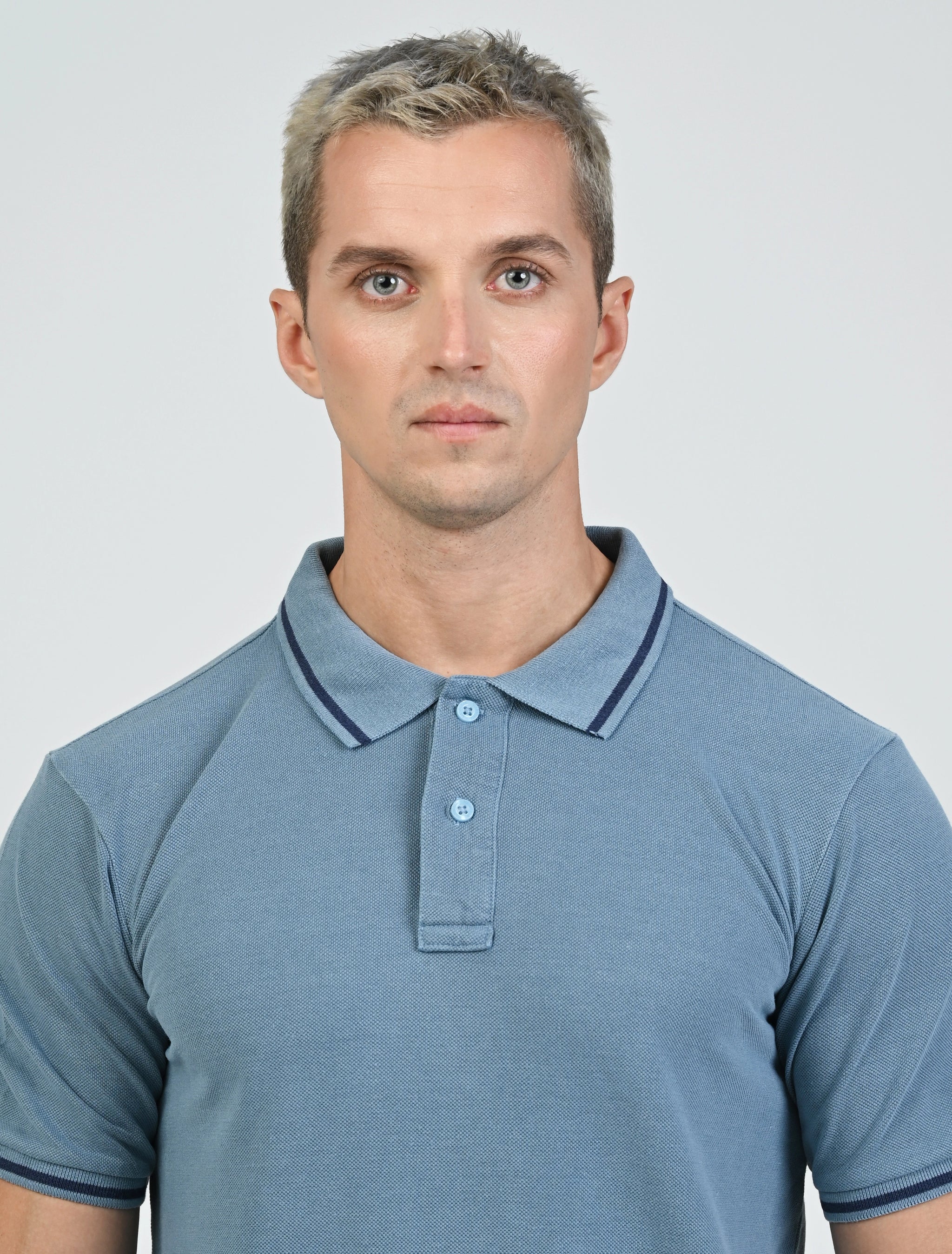 Close-up of the Marshall Menswear Saville Air Force Blue men's polo shirt highlighting the textured pique fabric, contrast blue tipping, classic polo collar and two-button placket.