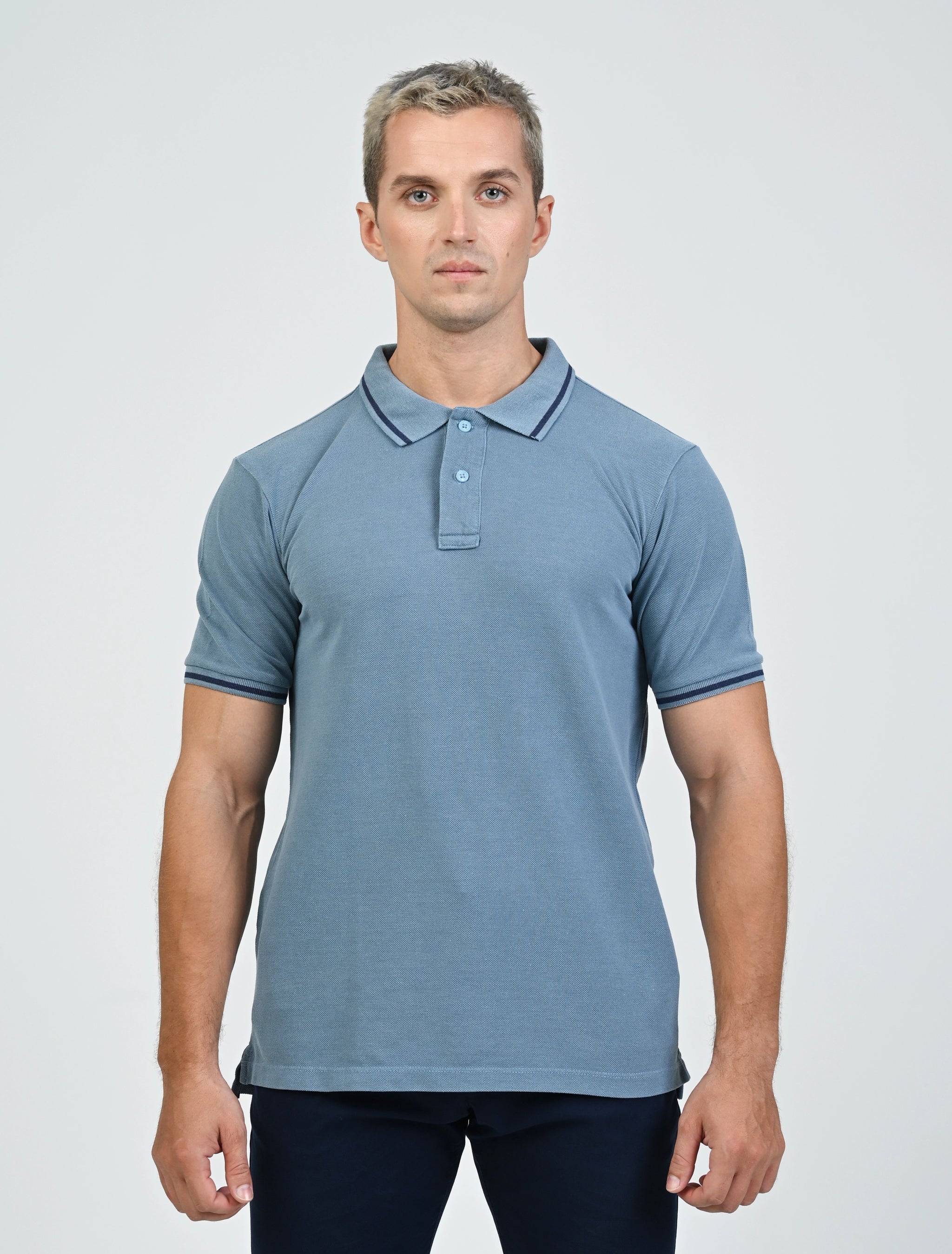 Model wearing the Marshall Menswear Saville Air Force Blue men's polo shirt with contrast blue tipping, paired with navy chinos for a refined smart casual look.